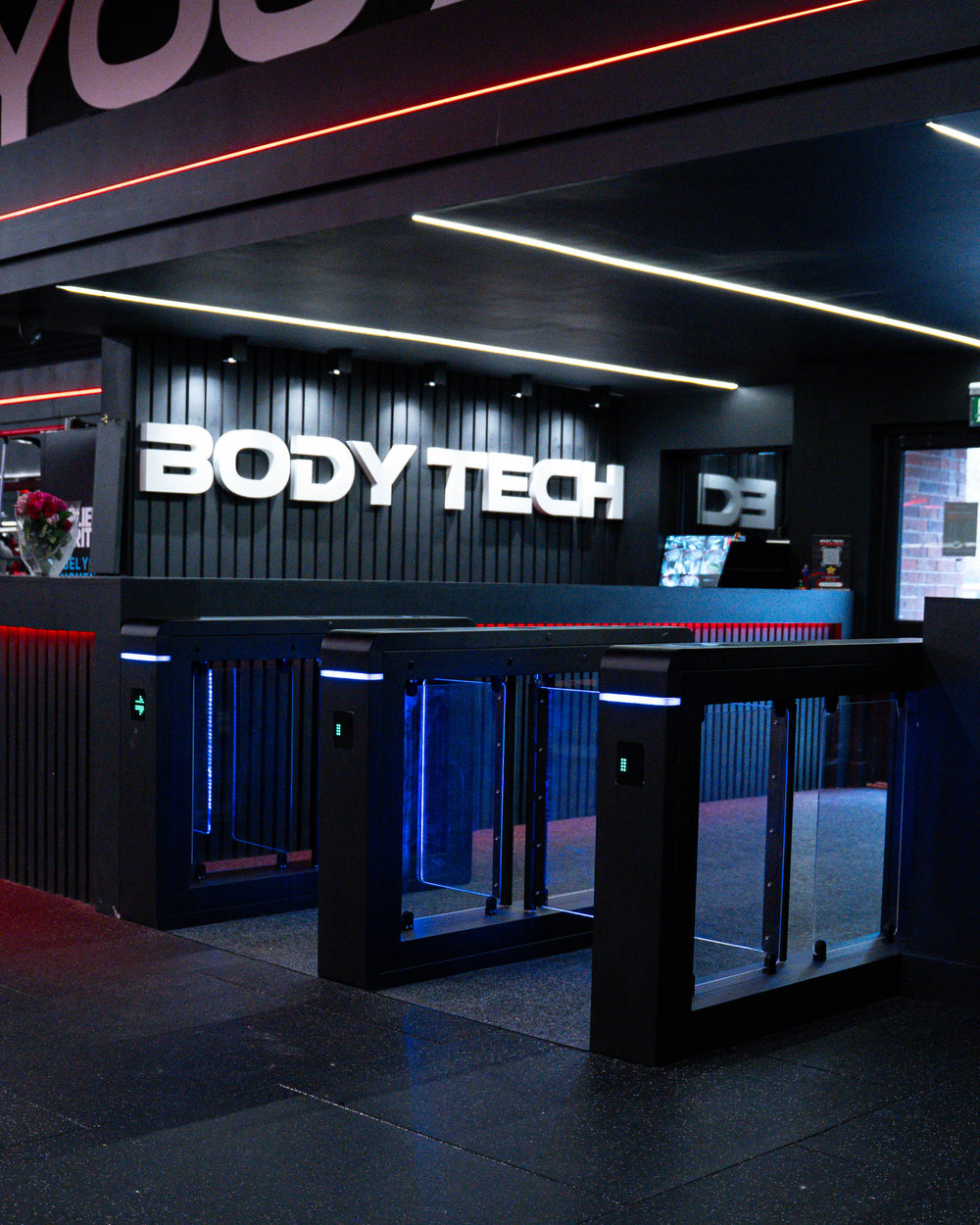 Speed gates at a gym entrance in front of the reception desk